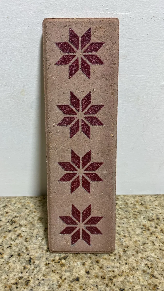Custom engraved thin brick sample with a repeating floral pattern